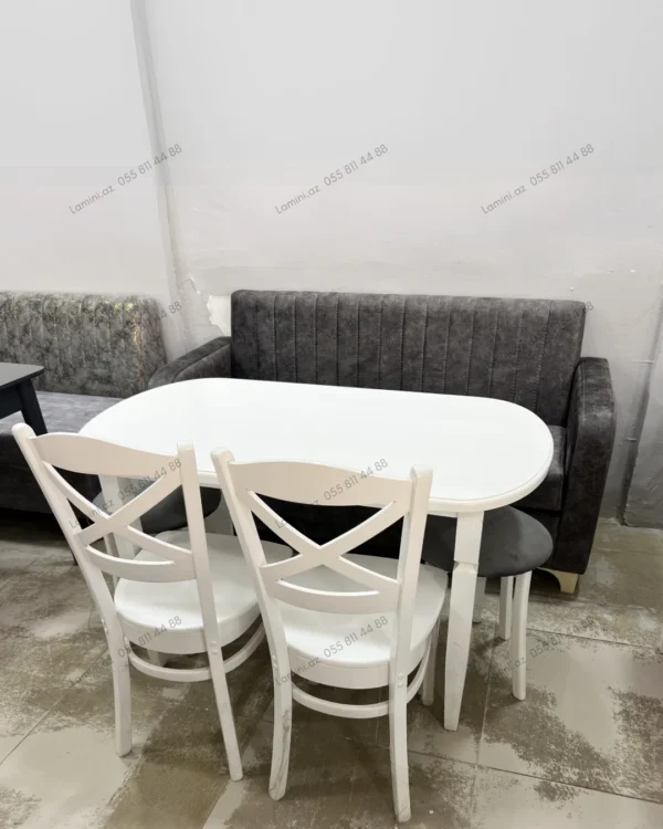 A dining room featuring a wooden table surrounded by four chairs, with soft lighting creating a warm atmosphere