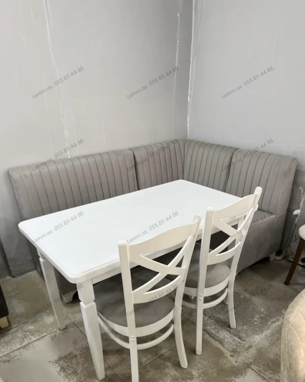 A dining room featuring a wooden table surrounded by four chairs, with soft lighting creating a warm atmosphere